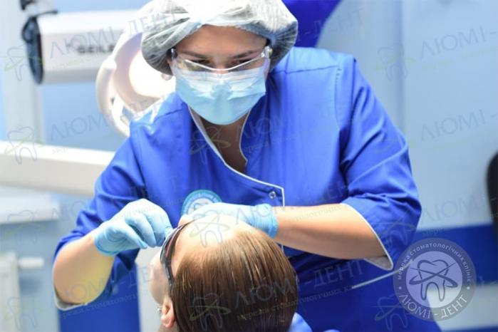Лікар проводить огляд ротової порожнини плями на язиці фото Люмі-Дент