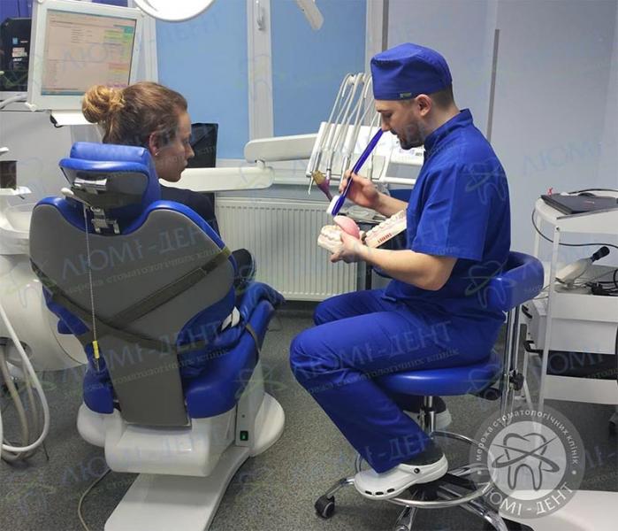 Терапевт з пацієнтом під час консультації Пече в роті фото Люмі-Дент